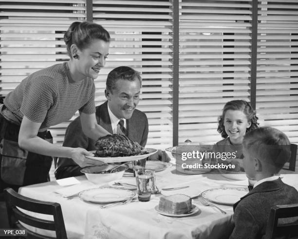 abendessen mit der familie, mutter hält teller mit roast - 1950s father stock-fotos und bilder