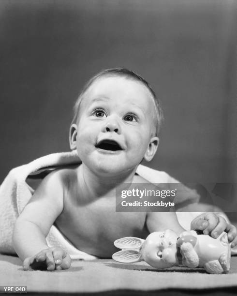 baby wrapped in blanket, holding toy rabbit - un solo niño bebé fotografías e imágenes de stock