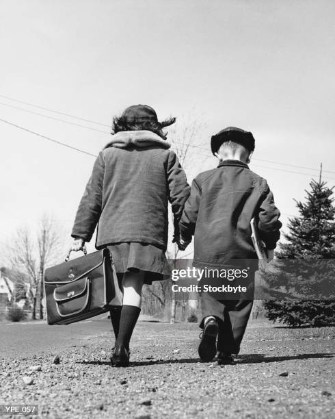 boy and girl holding hands, walking to school - his and hers stock pictures, royalty-free photos & images