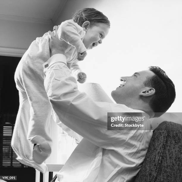 man raising baby over head - elite athlete kerri walsh jennings debuts her new kerri apparel line with asics in the heart of times square stockfoto's en -beelden