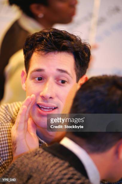 man whispering behind cupped hand to second man - 2nd annual leaders of spanish language television awards after party red stockfoto's en -beelden