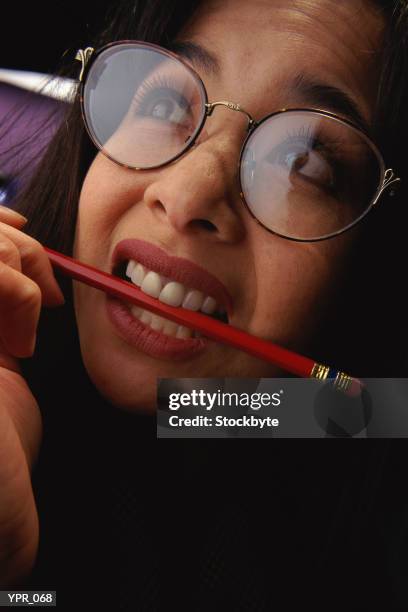 woman biting pencil - instrumento de escribir fotografías e imágenes de stock