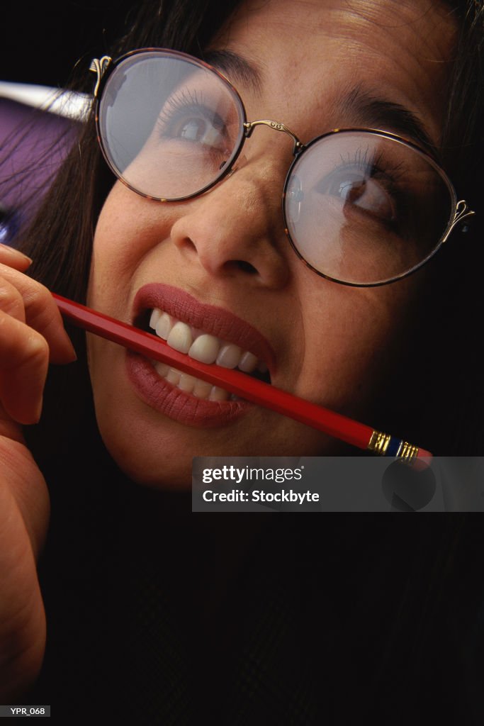 Woman biting pencil