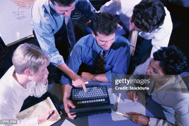 group of people gathered around laptop computer, overhead view - of fotografías e imágenes de stock