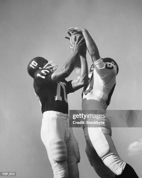 two football players jumping for ball at same time - american football strip stock pictures, royalty-free photos & images