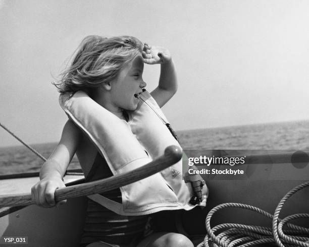 garota em barco à vela, vestindo jaqueta, segurando leme - in cima - fotografias e filmes do acervo