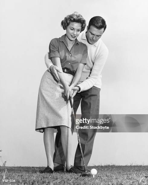 man teaching woman how to hit golfball - the queen duke of edinburgh attend evensong in celebration of the centenary of the order of the companions of honour stockfoto's en -beelden