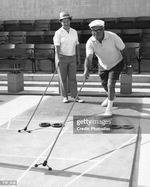 vecchia coppia giocare shuffleboard - non moving activity foto e immagini stock