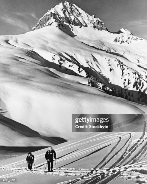 couple cross-country skiing in mountains - land feature stock pictures, royalty-free photos & images