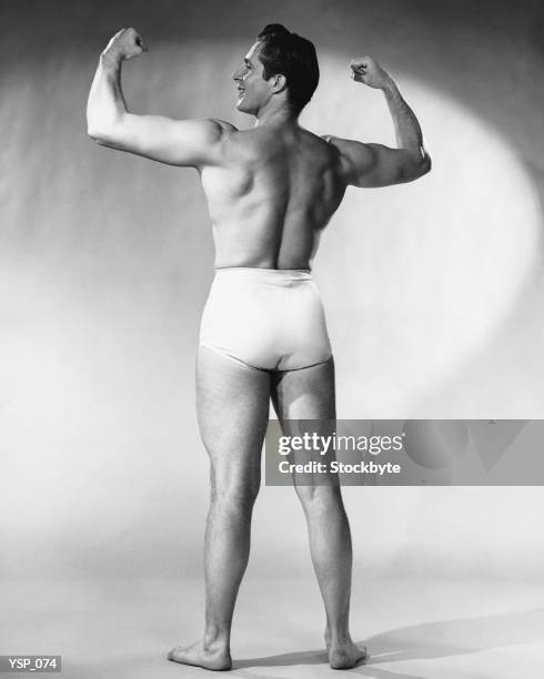 man flexing muscles - not looking at camera stock pictures, royalty-free photos & images