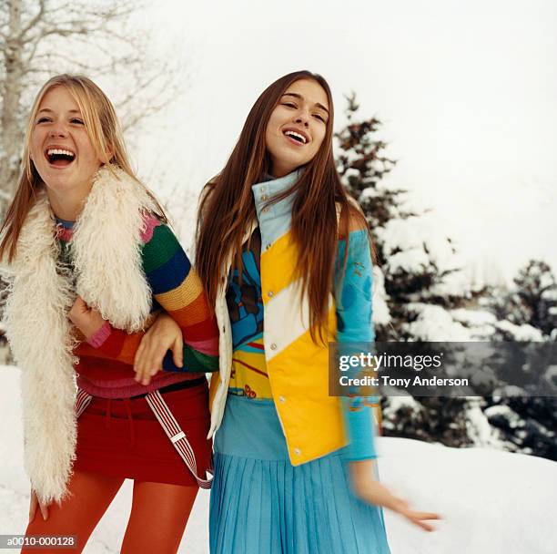 young women arm in arm in snow - women in suspenders fotografías e imágenes de stock