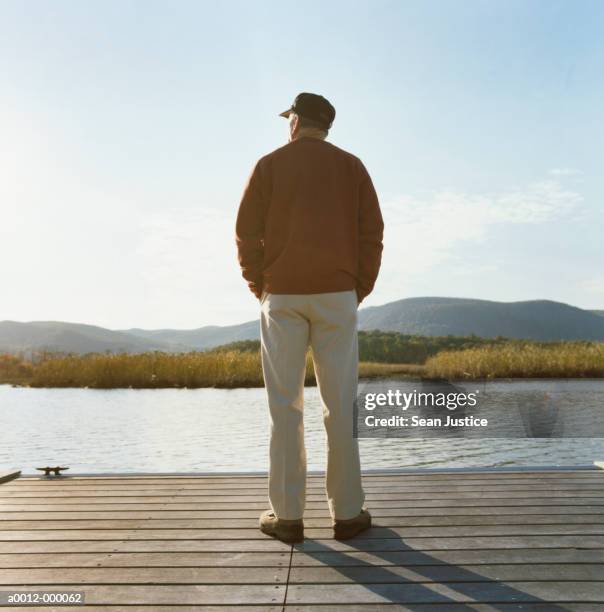 man standing on pier near lake - man standing back view stock pictures, royalty-free photos & images
