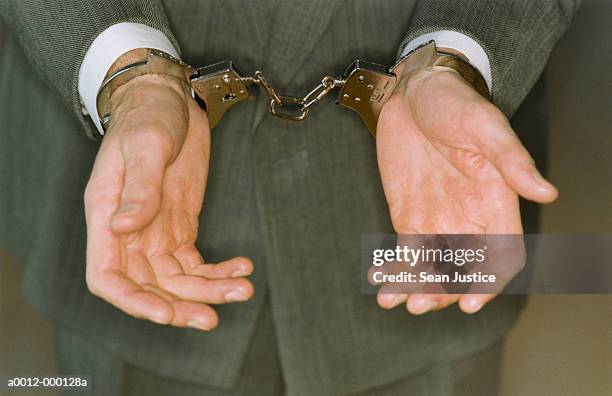 businessman in handcuffs - cuff stock-fotos und bilder