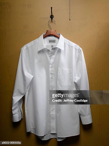 white shirt on closet door - white shirt stock-fotos und bilder