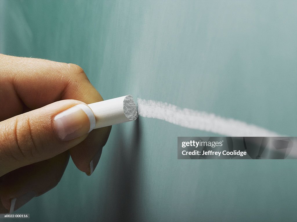 Hand Draws Line on Blackboard