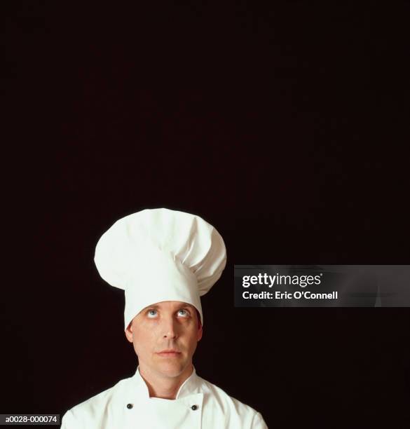 curious looking chef - kochmütze stock-fotos und bilder