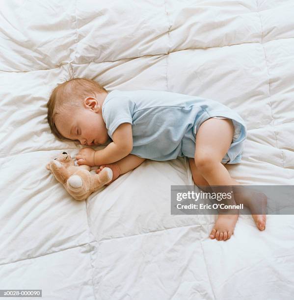 baby sleeping on bed - sleeping baby stockfoto's en -beelden