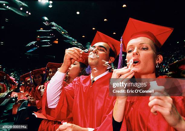 graduates blowing bubbles - graduation crowd stock-fotos und bilder