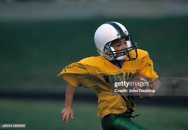 boy runs with football - rush american football stockfoto's en -beelden