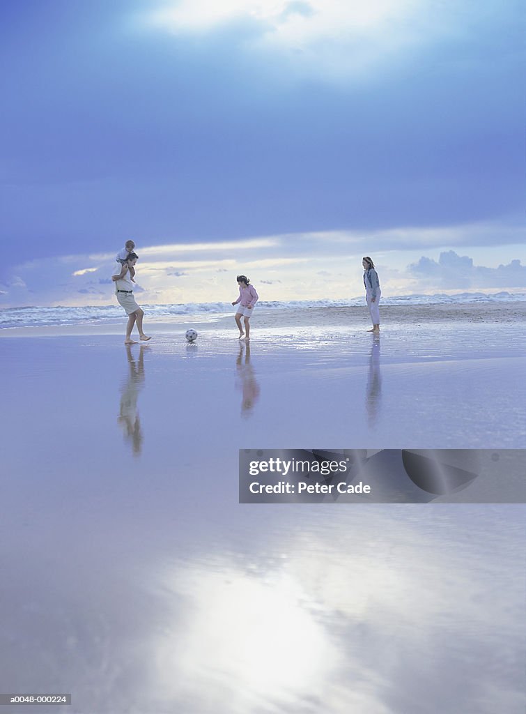 Family Playing Soccer on Beach