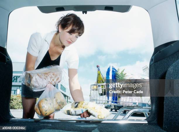 woman loading groceries in car - full car trunk stock pictures, royalty-free photos & images