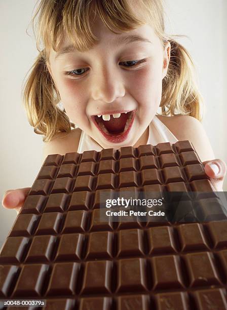 girl holding chocolate - girl open mouth stockfoto's en -beelden