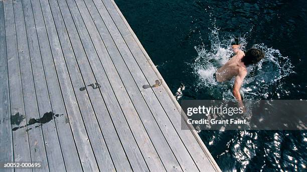 boy jumping into lake - footsteps on a boardwalk bildbanksfoton och bilder