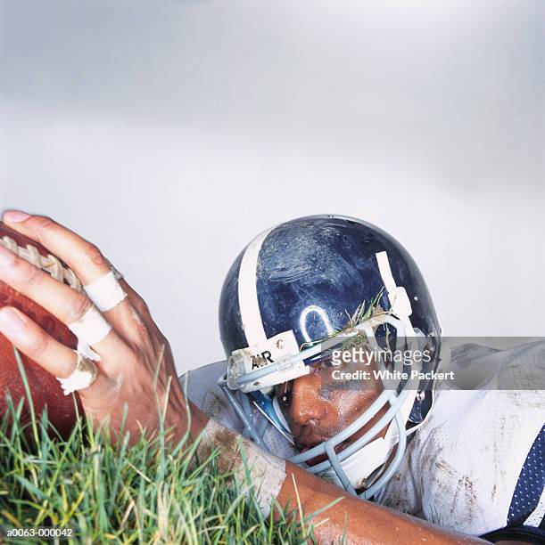 football player holding ball - american football strip stock pictures, royalty-free photos & images