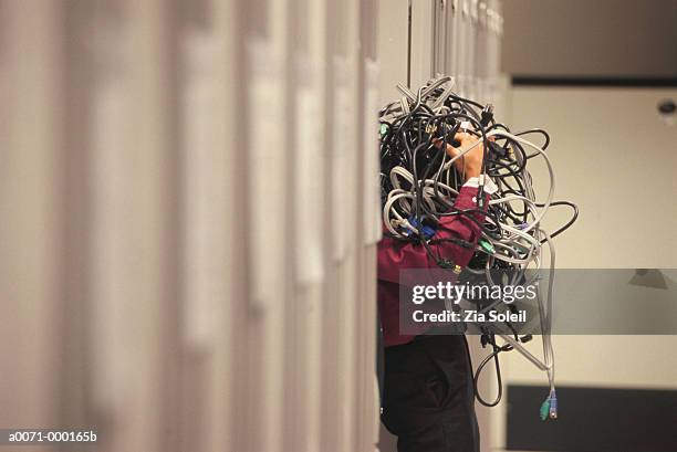 man holding bundle of wiring - stack of computer servers stock pictures, royalty-free photos & images