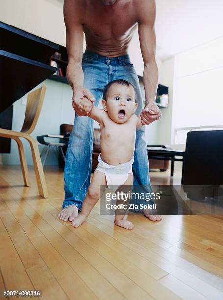 father helping toddler to walk - baby standing stock pictures, royalty-free photos & images