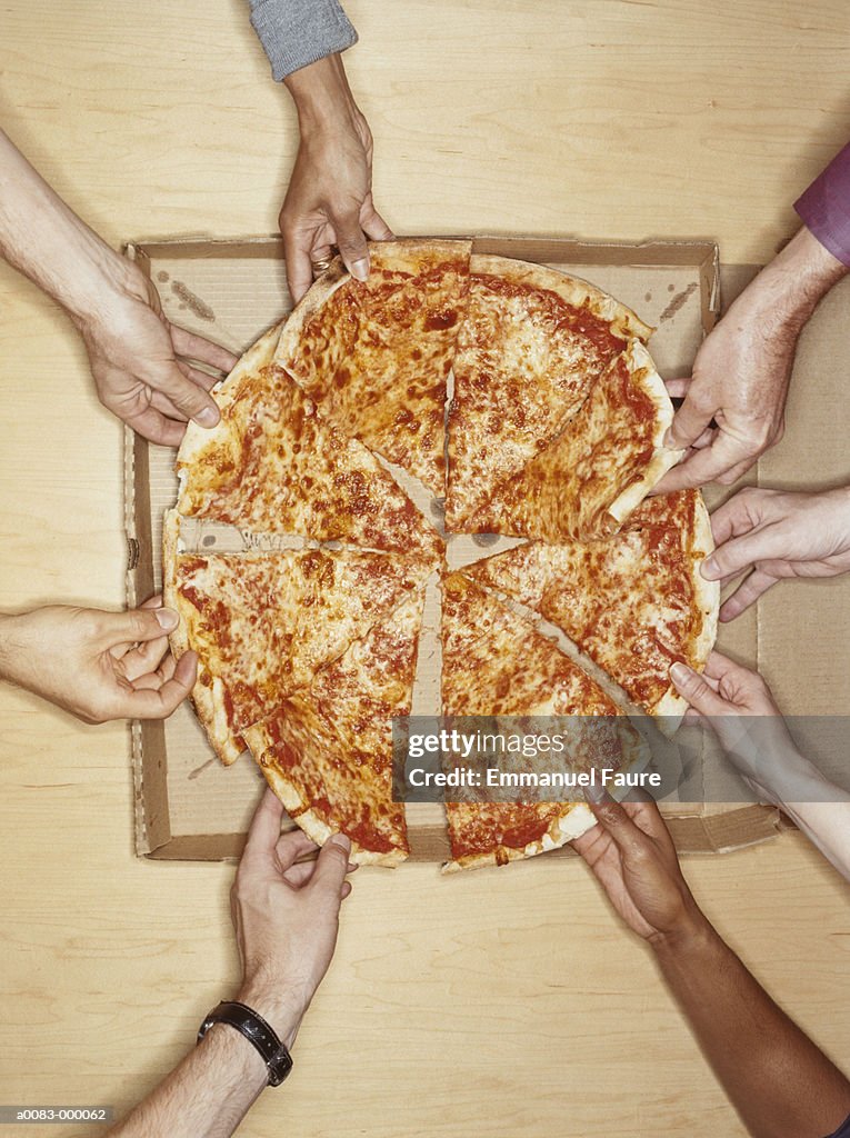 Hands Holding Pizza Slices