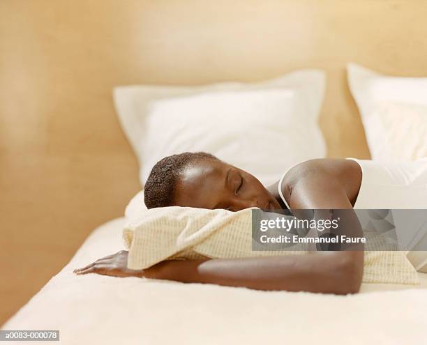 woman sleeping on bed - black man sleeping in bed stock-fotos und bilder