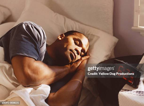 man sleeping in bed - dormir fotografías e imágenes de stock