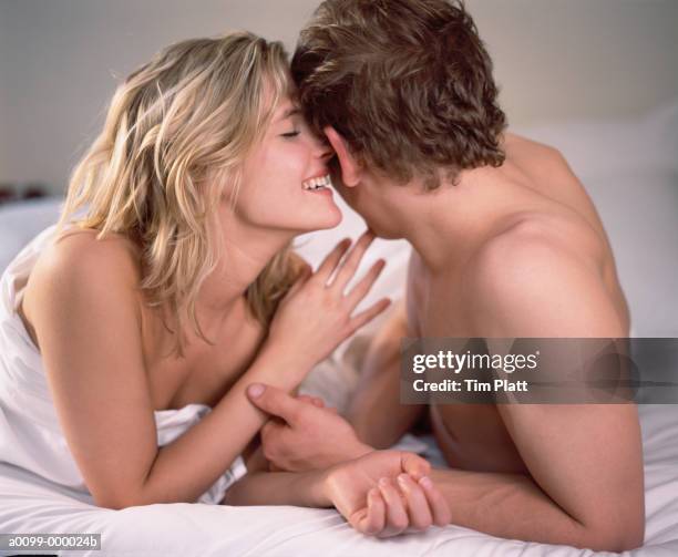 girl whispering in man's ear - woman whisper to man stock pictures, royalty-free photos & images