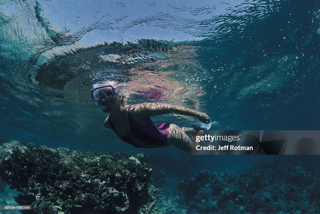 Woman Swimming over Coral