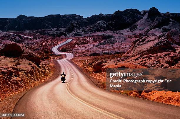 motorcyclist on empty road - nevada road stock pictures, royalty-free photos & images