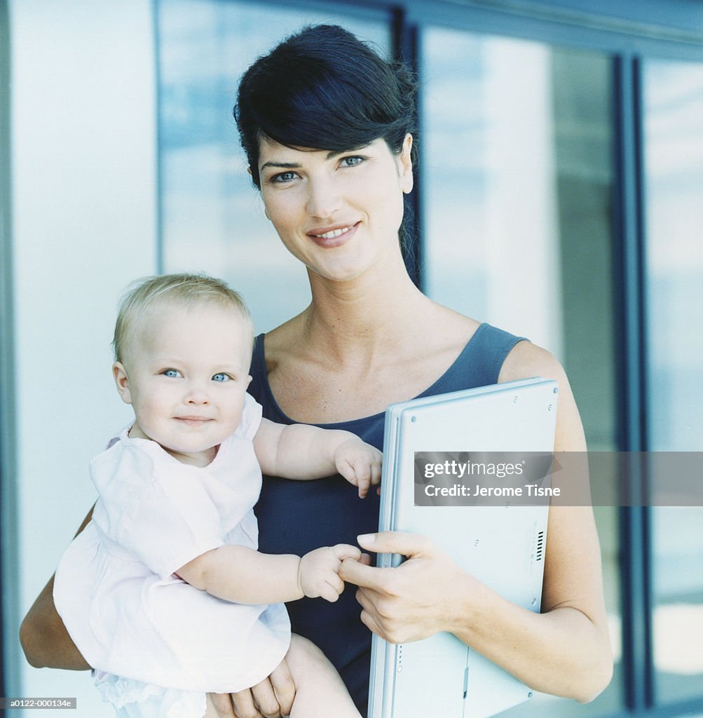 Mother Holding Baby and Laptop