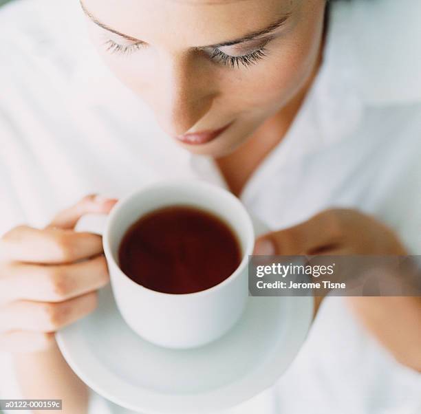 woman holding cup of tea - tè nero foto e immagini stock