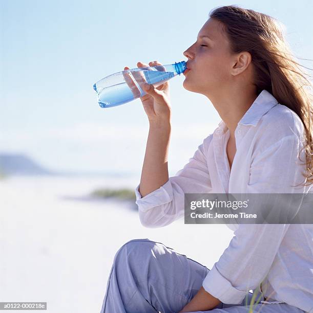 woman drinking water - female hand holding water bottle stock pictures, royalty-free photos & images