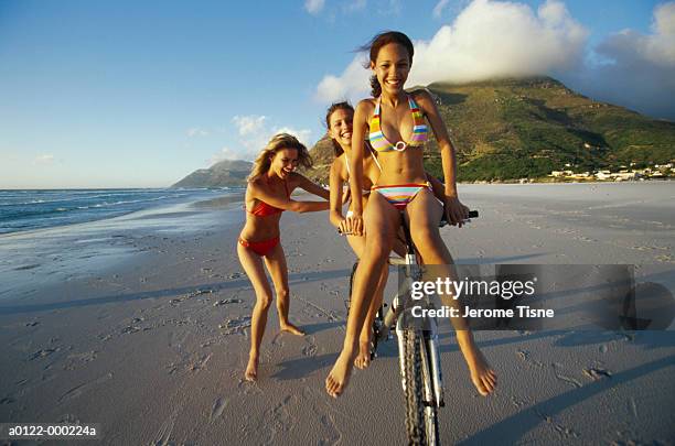 friends and bicycle on beach - bike beach stock-fotos und bilder