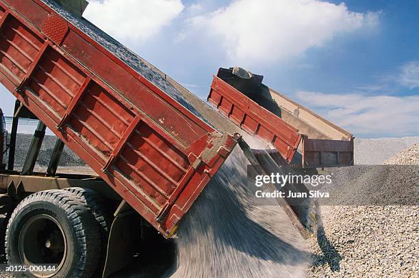 trucks unloading gravel - schottergestein stock-fotos und bilder