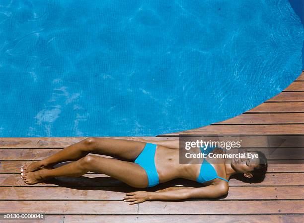 woman sunbathes near pool - tanned body stock pictures, royalty-free photos & images
