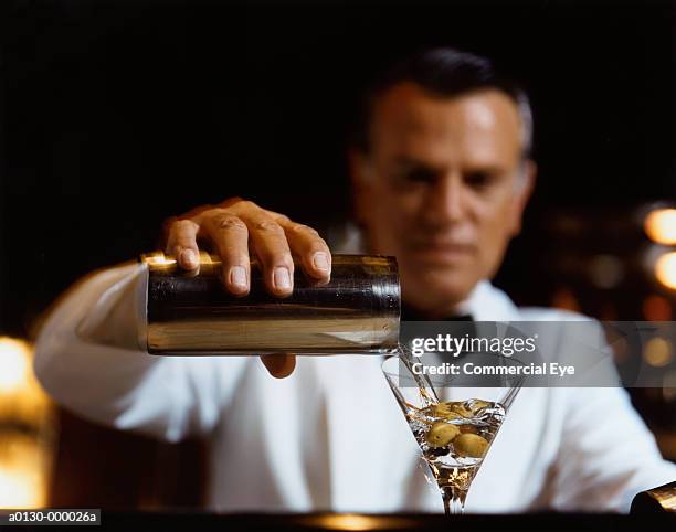 bartender pours martini - olive fruit stockfoto's en -beelden