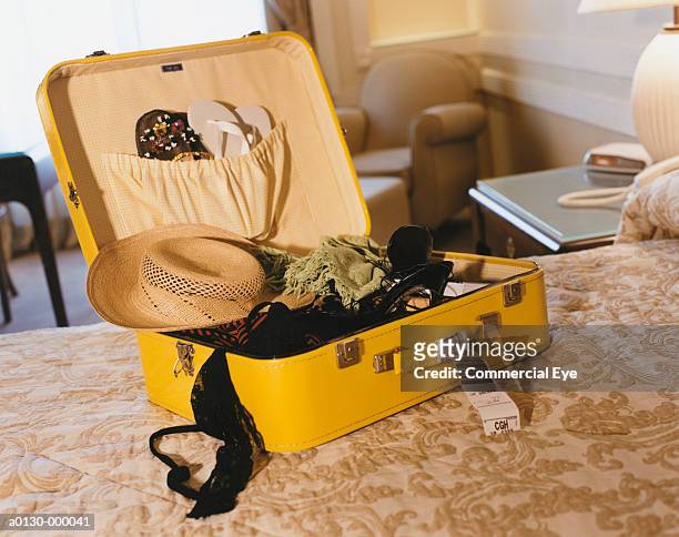 open suitcase on bed - yellow hat stock pictures, royalty-free photos & images