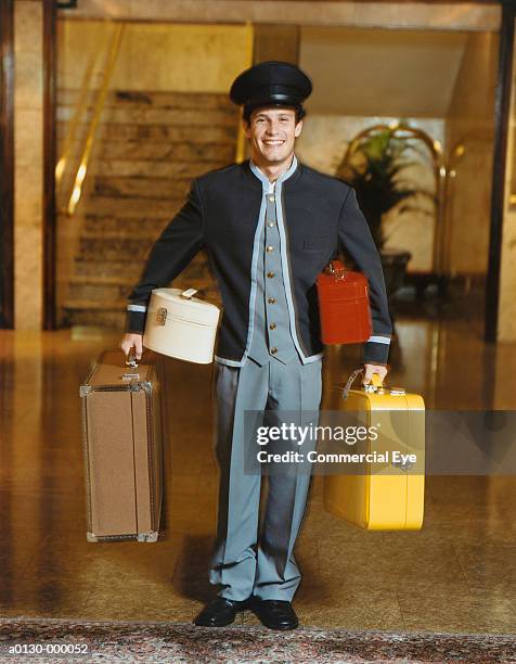 bellhop holding suitcases - bell boy stock pictures, royalty-free photos & images