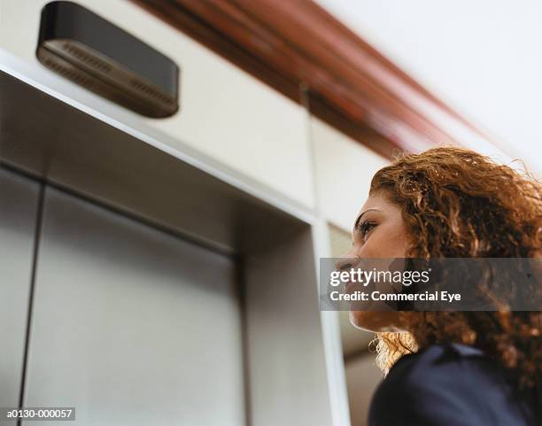 woman waiting for elevator - elevator fotografías e imágenes de stock