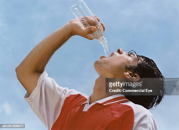 soccer player drinking water - bottle water stock-fotos und bilder