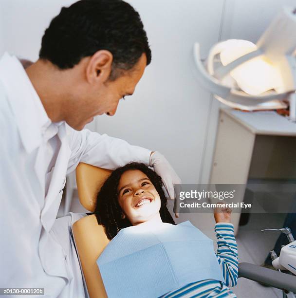 young girl grinning at dentist - odontopediatría fotografías e imágenes de stock