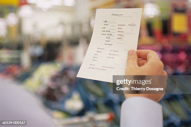 hand holding shopping list - einkaufszettel stock-fotos und bilder