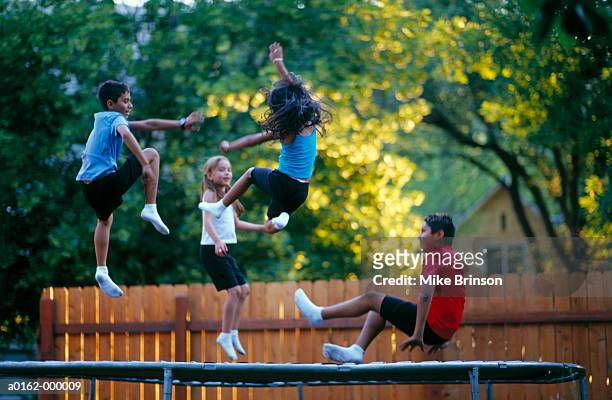 children jumping on trampoline - trampoline stock pictures, royalty-free photos & images